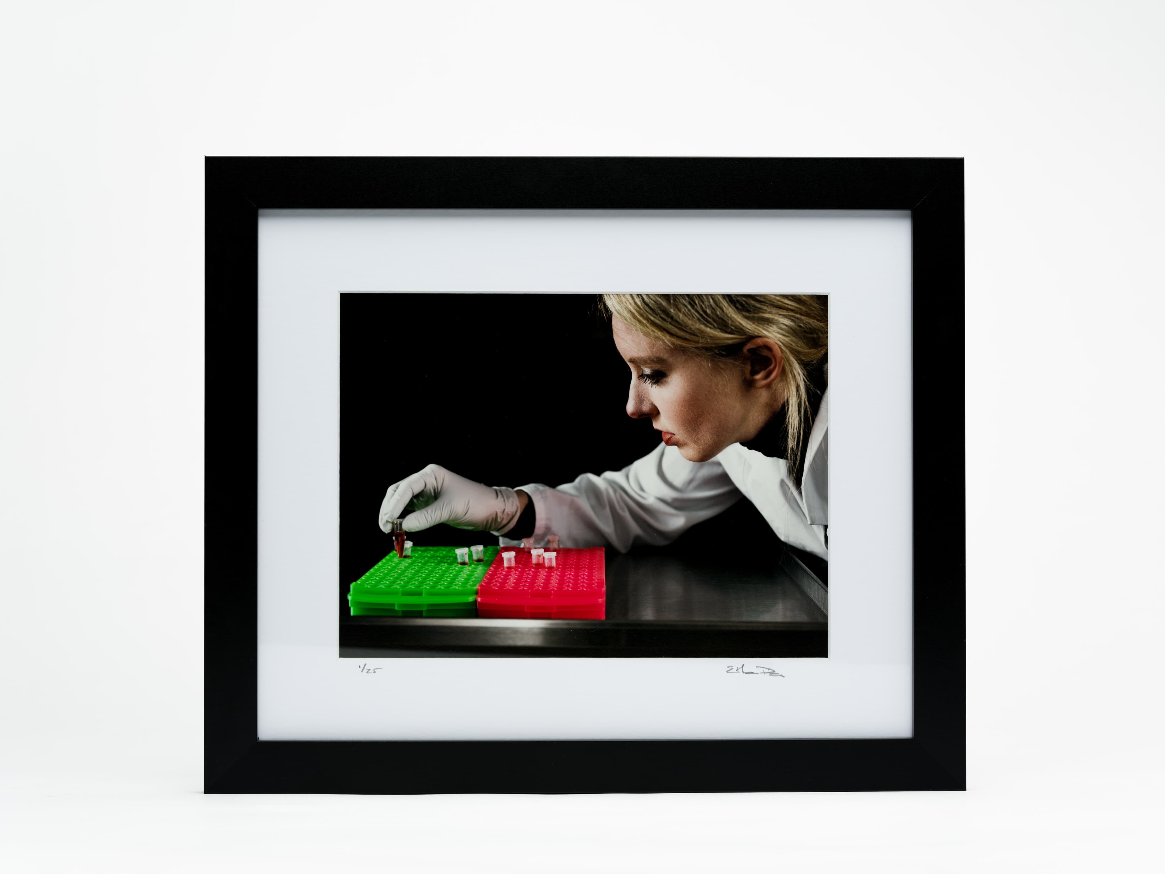 Framed photograph of Elizabeth Holmes using a pipette
